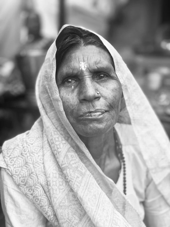 an indian woman with a painted forehead stares into the camera