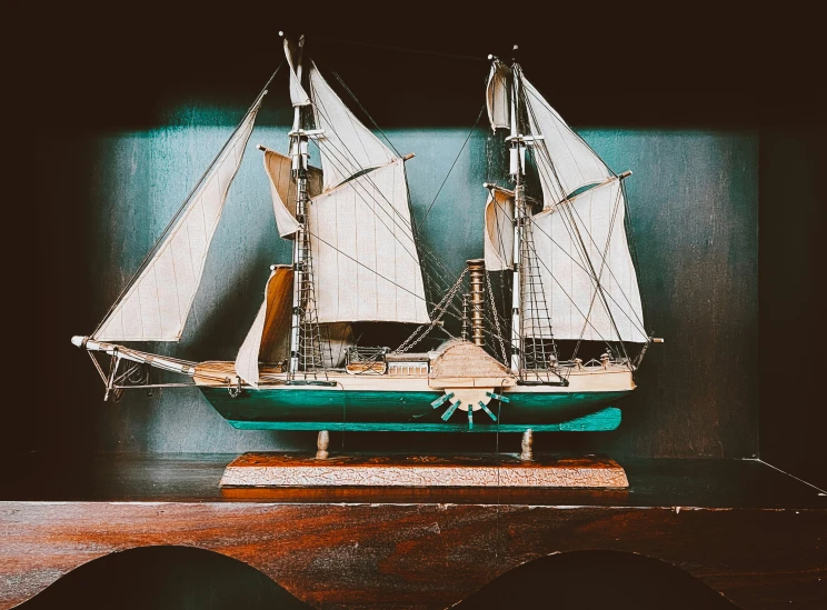 a small toy boat on display next to a wall