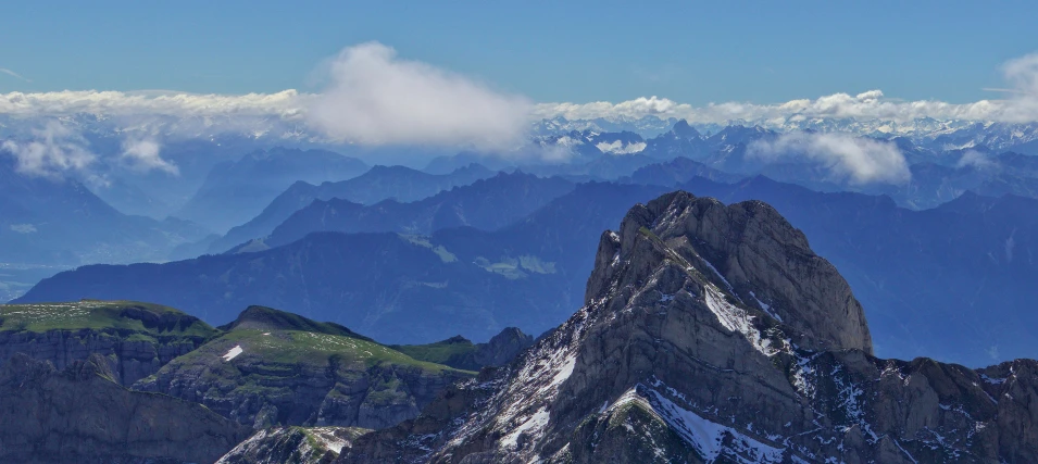 the view from the top of mountain, with many peaks, below clouds