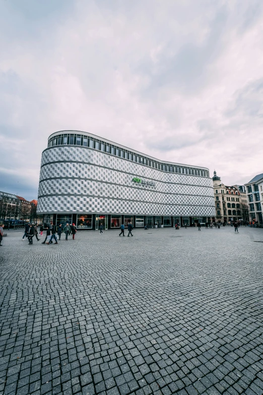 people walk through an empty courtyard of a building