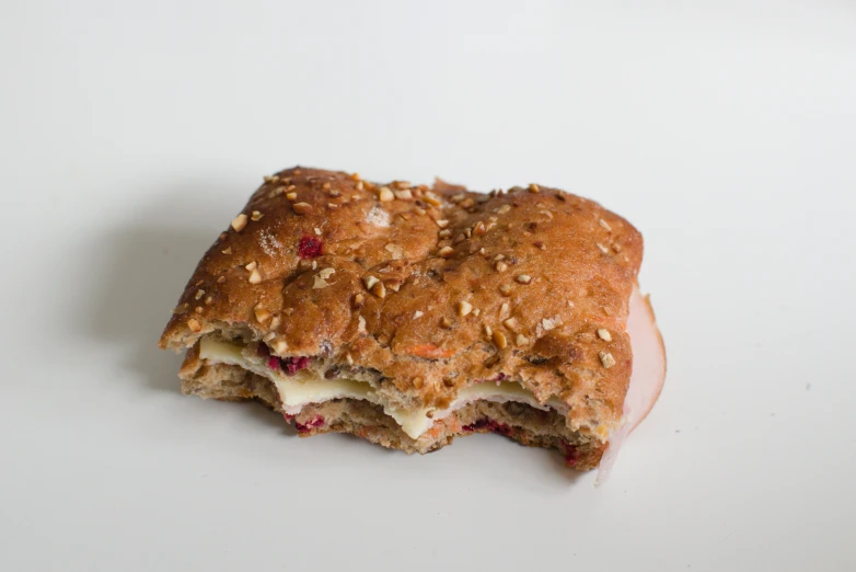 a sandwich with nuts is on the white surface