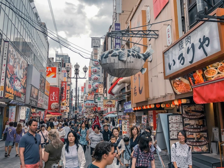 a crowded city street with people and businesses