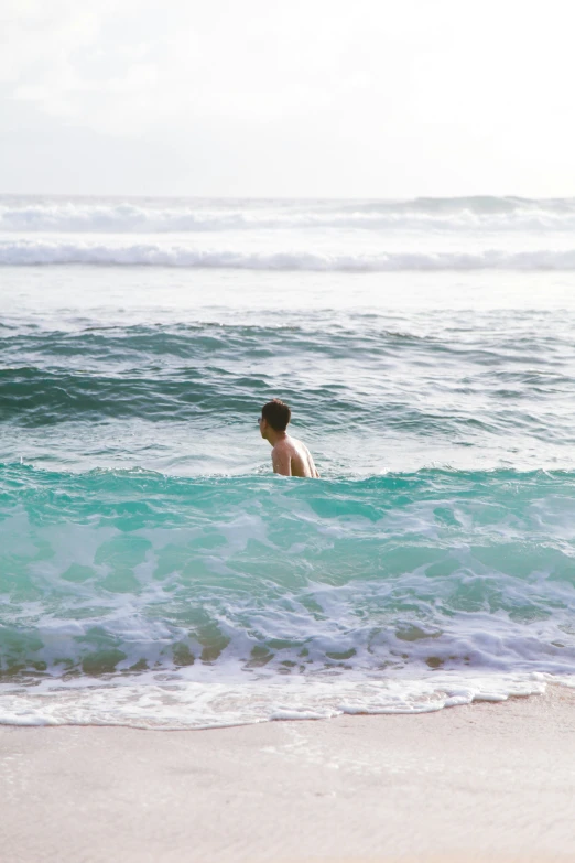 someone swimming with the ocean waves behind them