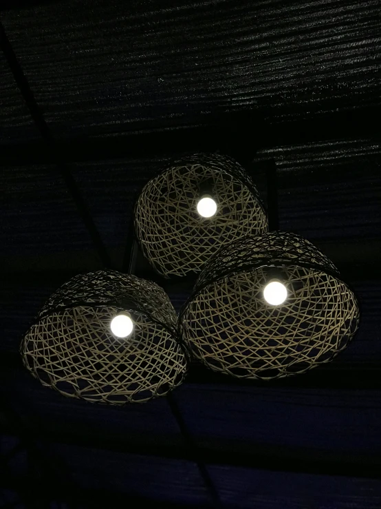 three lights with holes are lit up in the dark