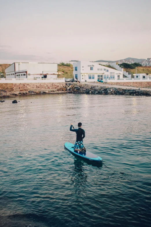 a man riding a blue surfboard in the water