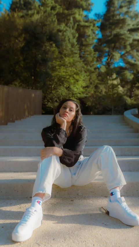 a woman with long hair sitting on a white staircase