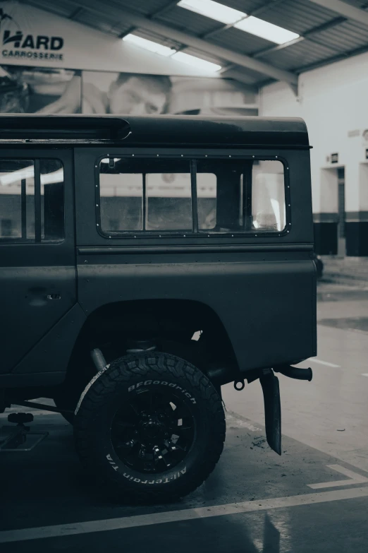 black and white pograph of a jeep at a station