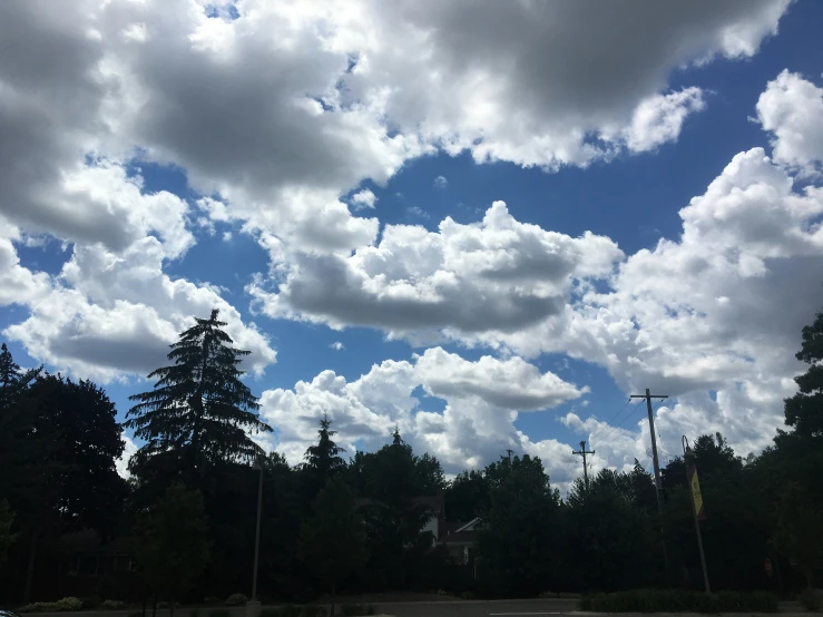 some clouds that are near trees and houses