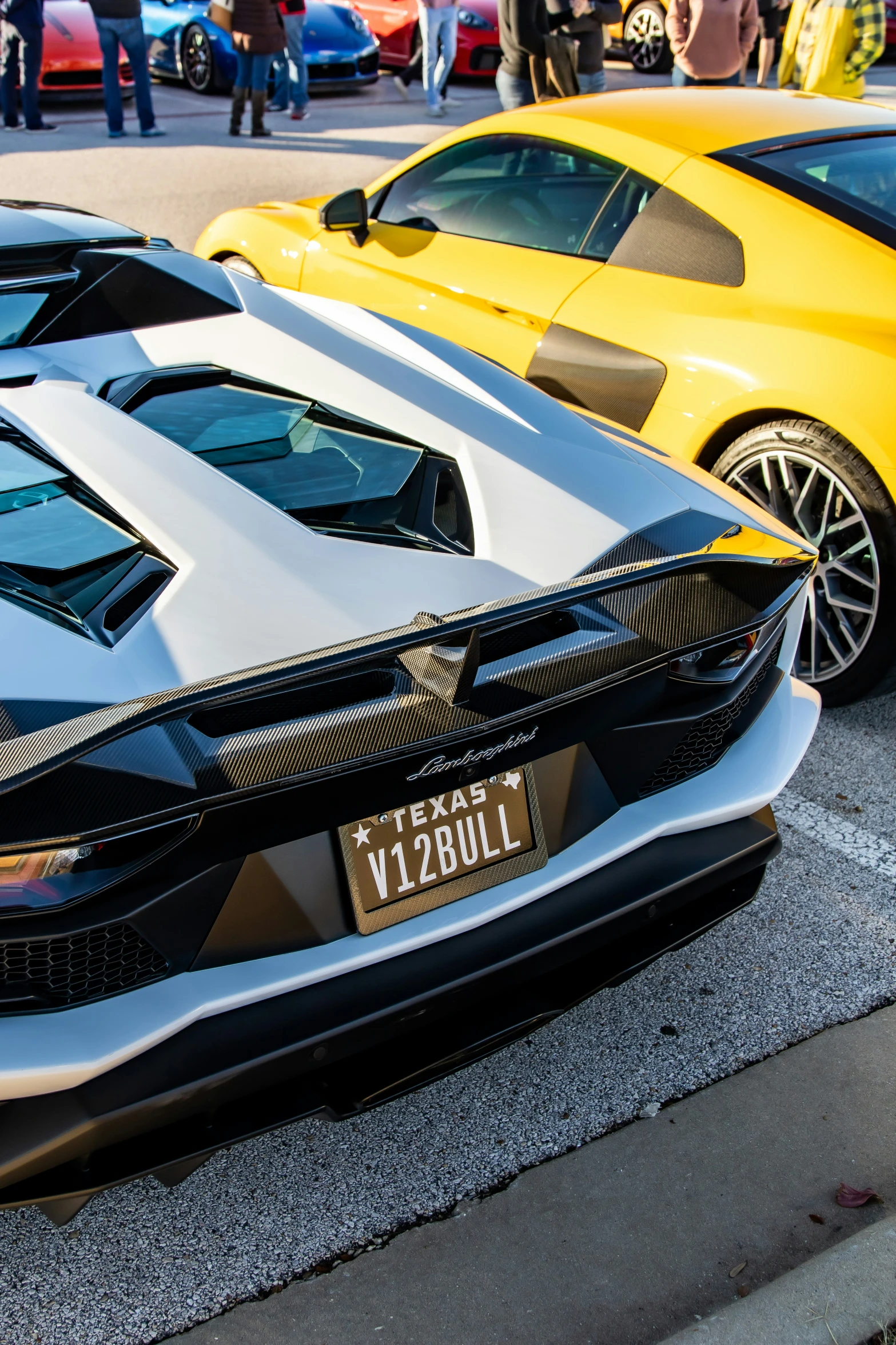 a couple of cars parked next to each other in front of some people