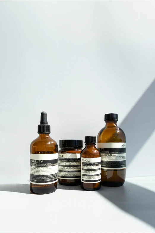 three bottles of brown liquid on a white table