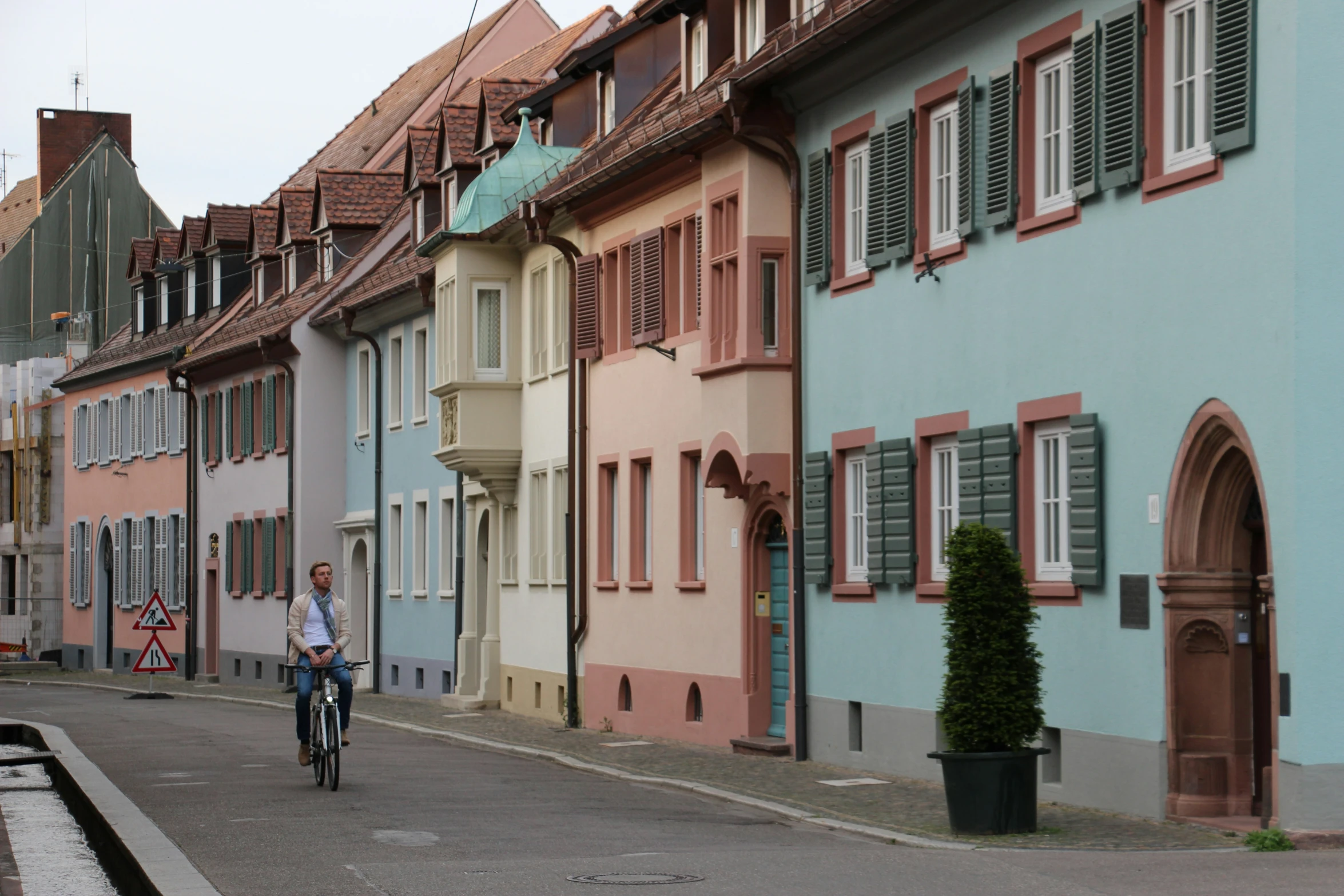 a person riding a bike down a street near buildings