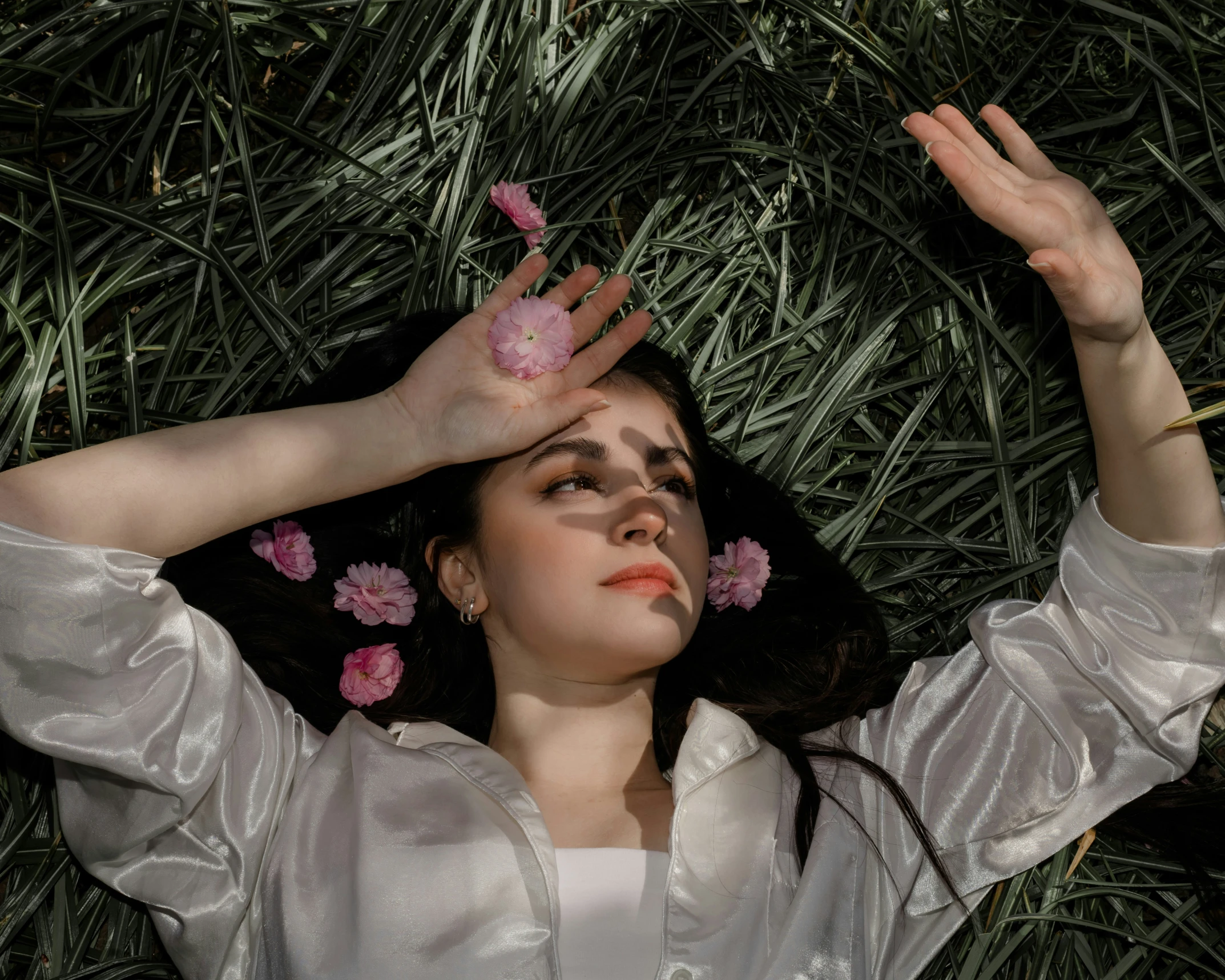 a woman with pink flowers floating from her hair