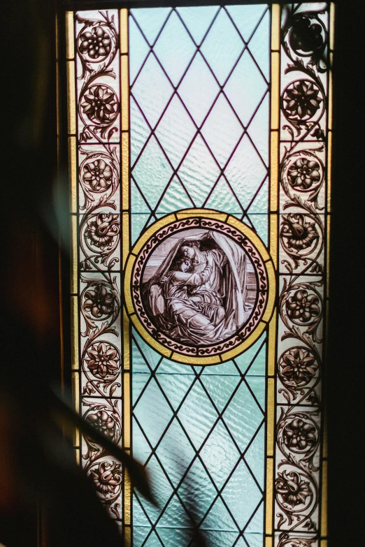 a stain glass depicting an image of christ with angel