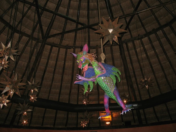 an elaborate chandelier decorated with brightly colored bird and stars