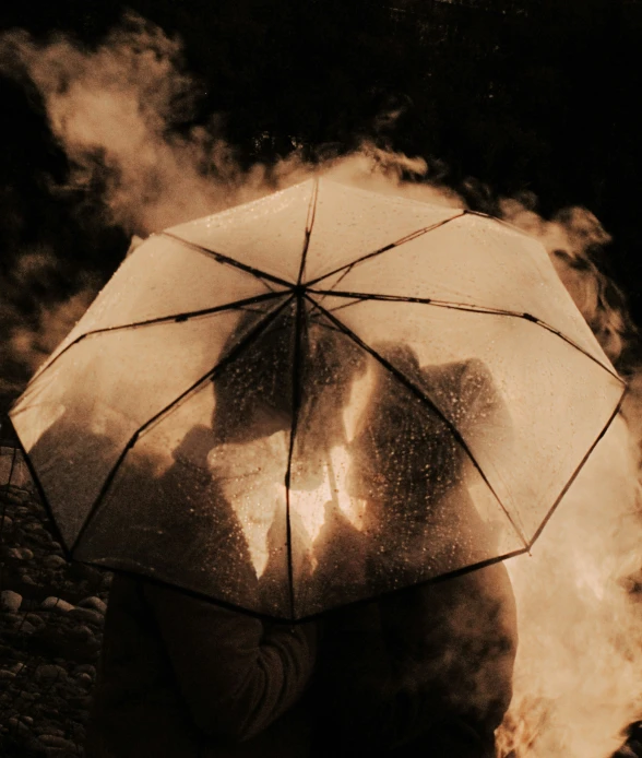 a person standing underneath an umbrella on a cloudy day