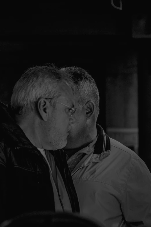 a man and woman share a kiss as they sit together