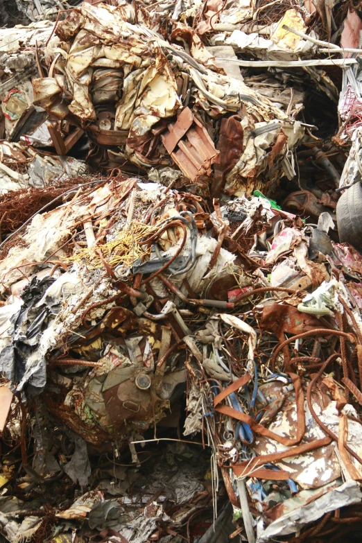 a pile of metal scrap next to a pile of broken and trash cans