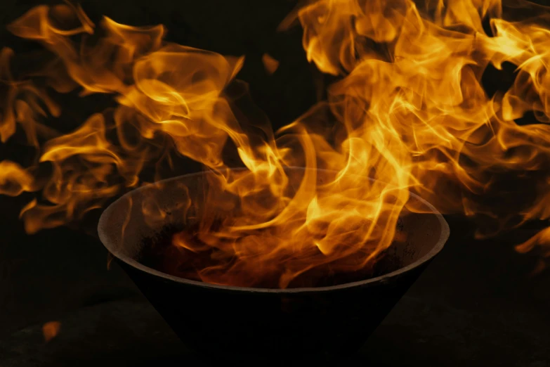 the bowl is on fire against a black background