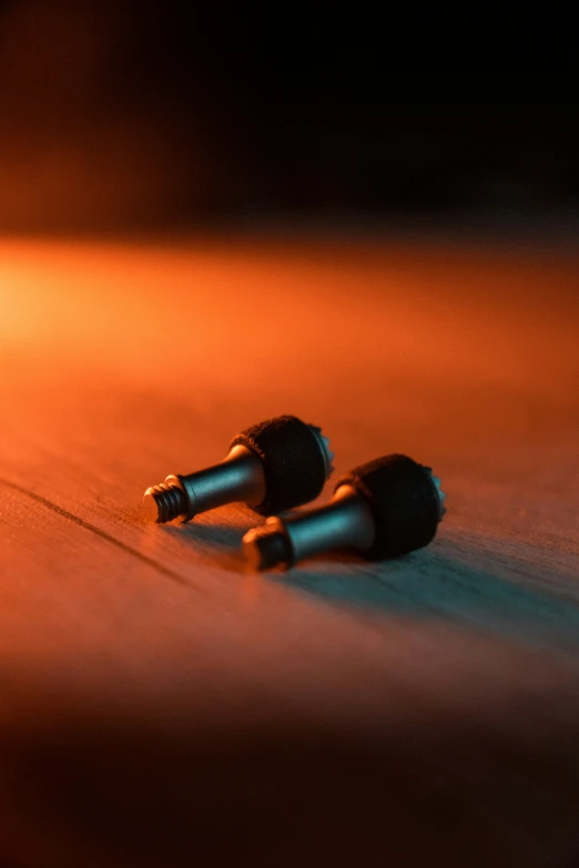 a pair of ear buds sitting on top of a wooden floor