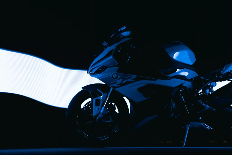 a motorcycle parked next to a wall with a white wave