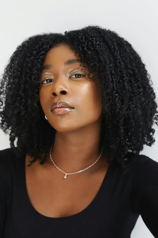 a woman with an afro wearing a black top