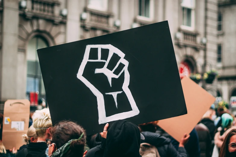 someone holding up a sign with a fist