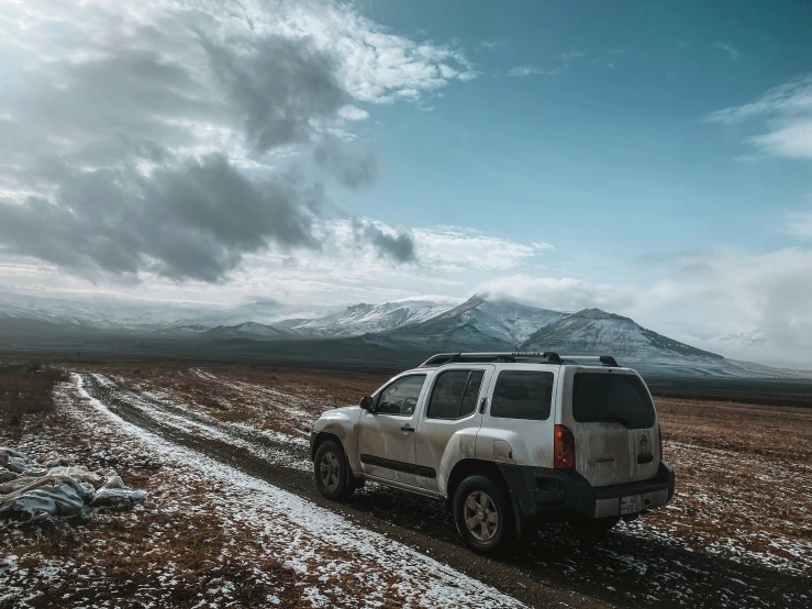 there is a suv that is on the dirt road