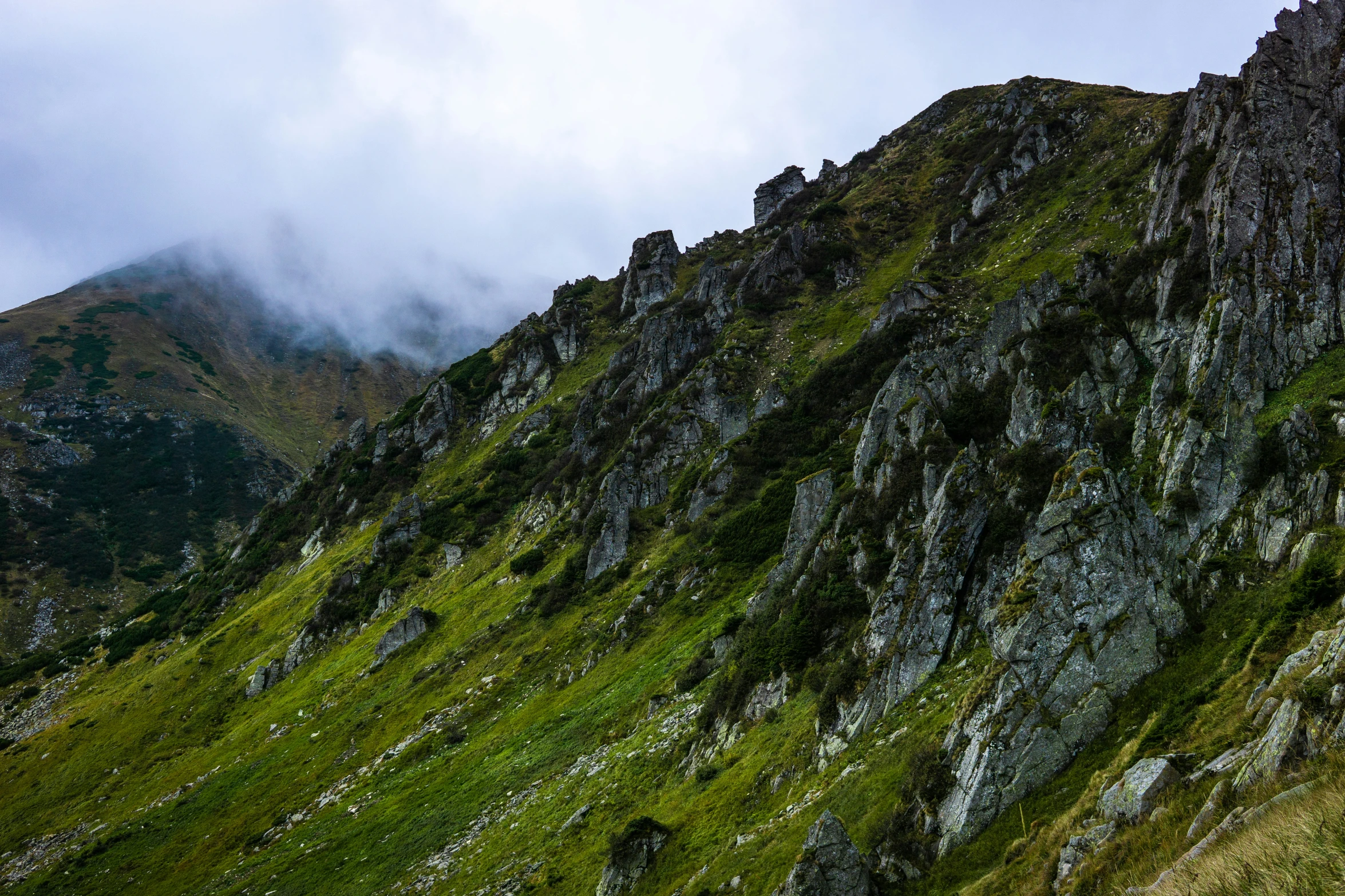 a large mountain with grass on top of it