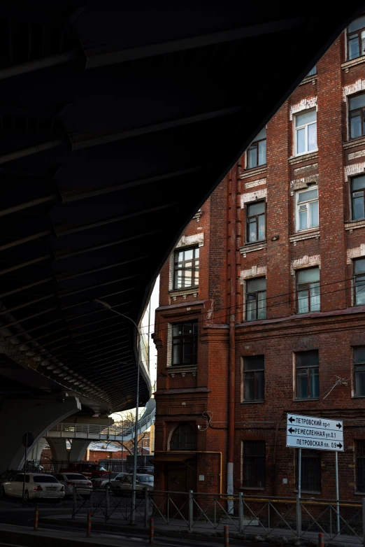 a tall building under a bridge with an empty street