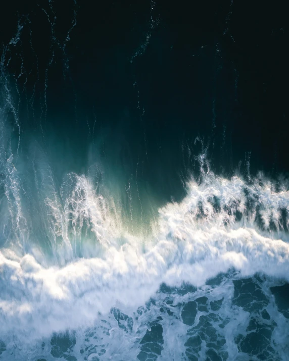 a very large ocean wave is breaking into shore