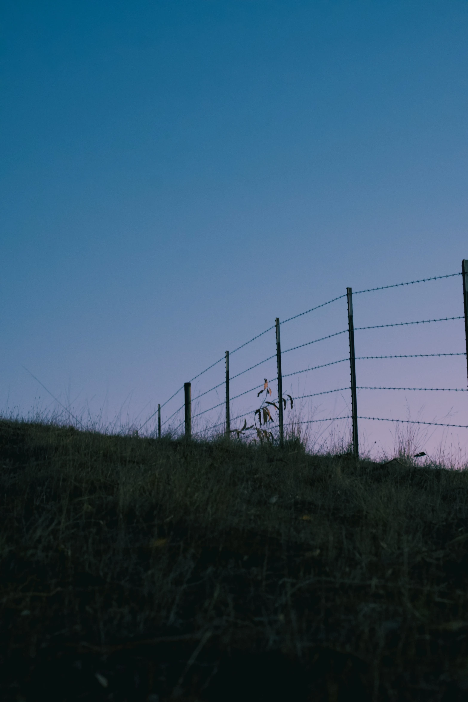 the silhouette of a man sitting on a hill