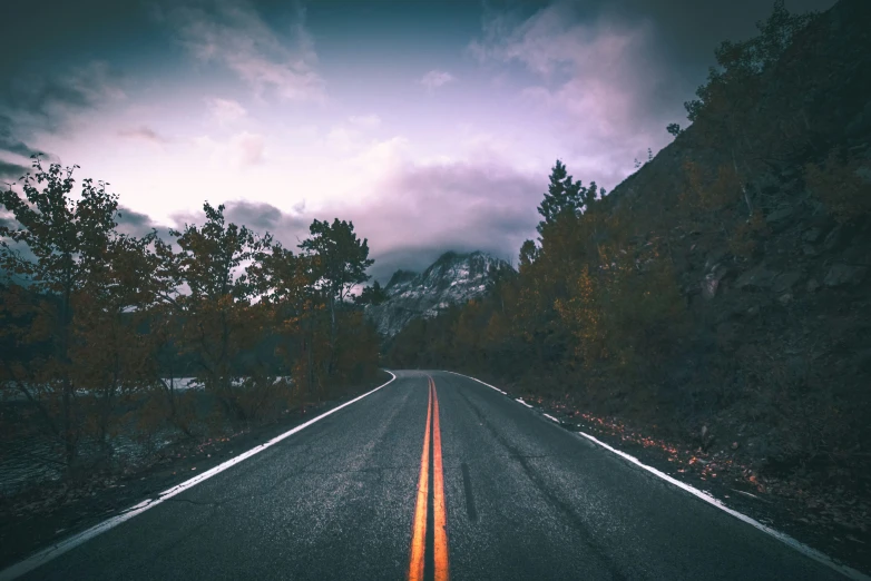 the view down an empty road in the evening time