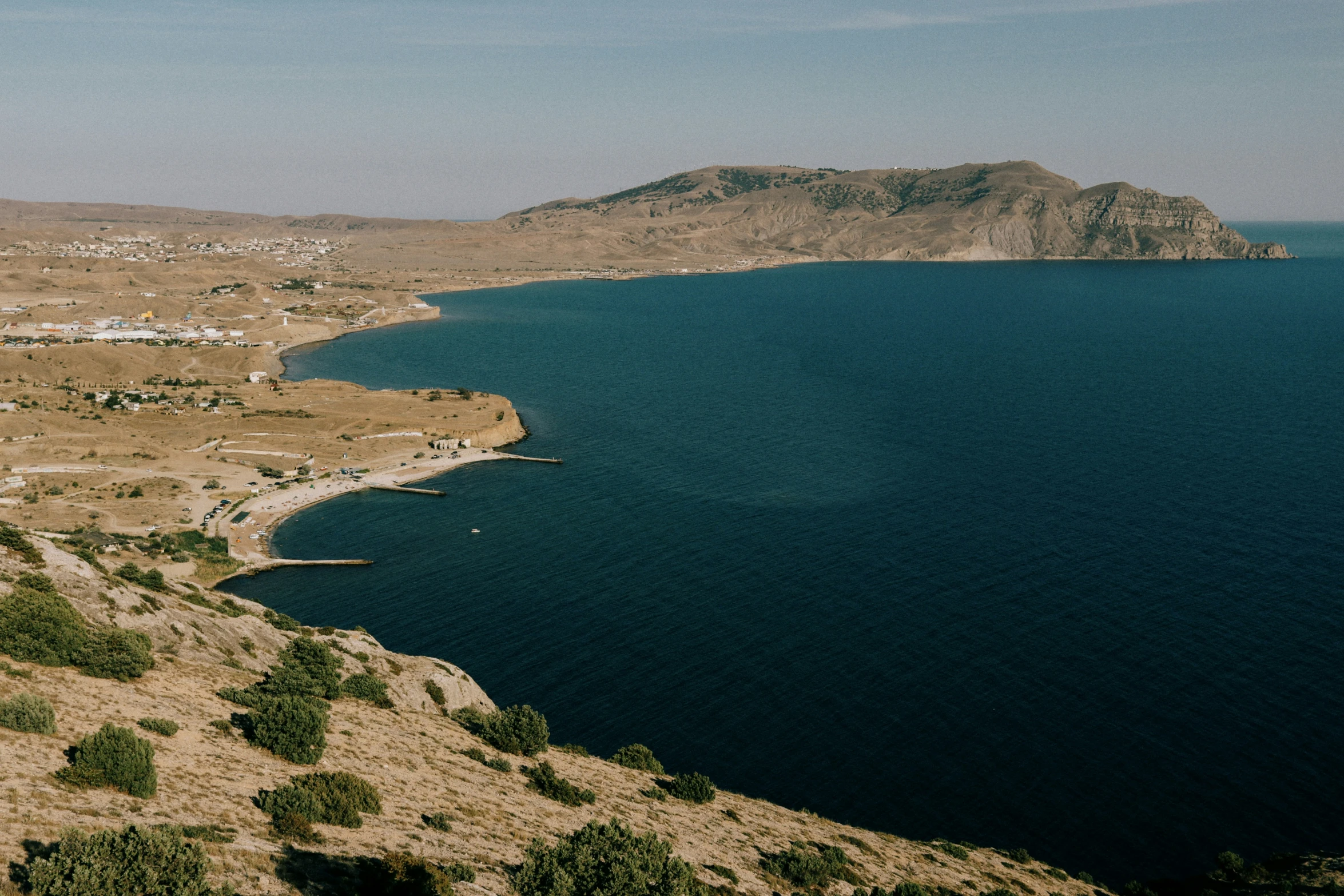 a mountain overlooks the coast line in front of a blue lake