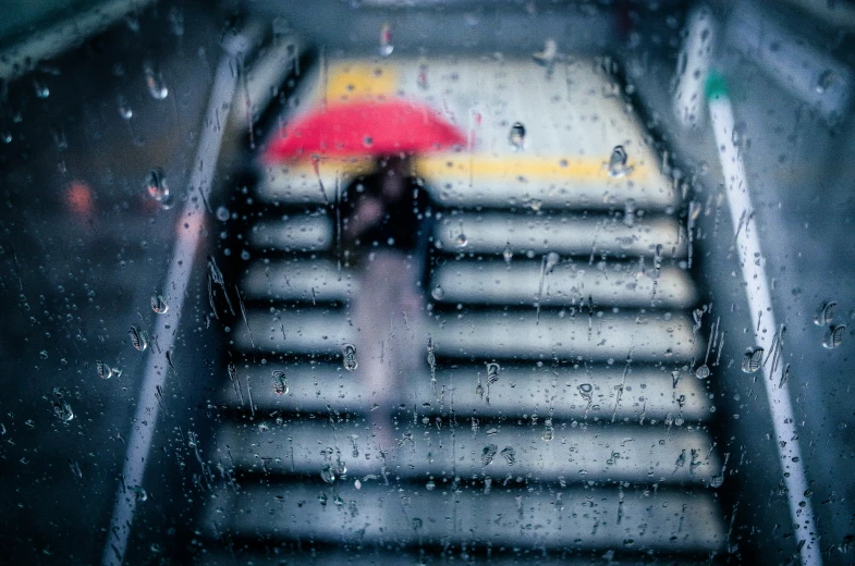 an person is walking up some stairs with a red umbrella