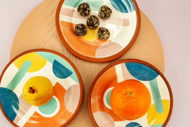 three plates with designs with oranges on them