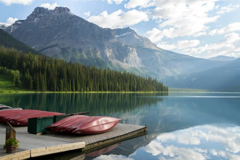 red canoes are docked on a dock on the lake