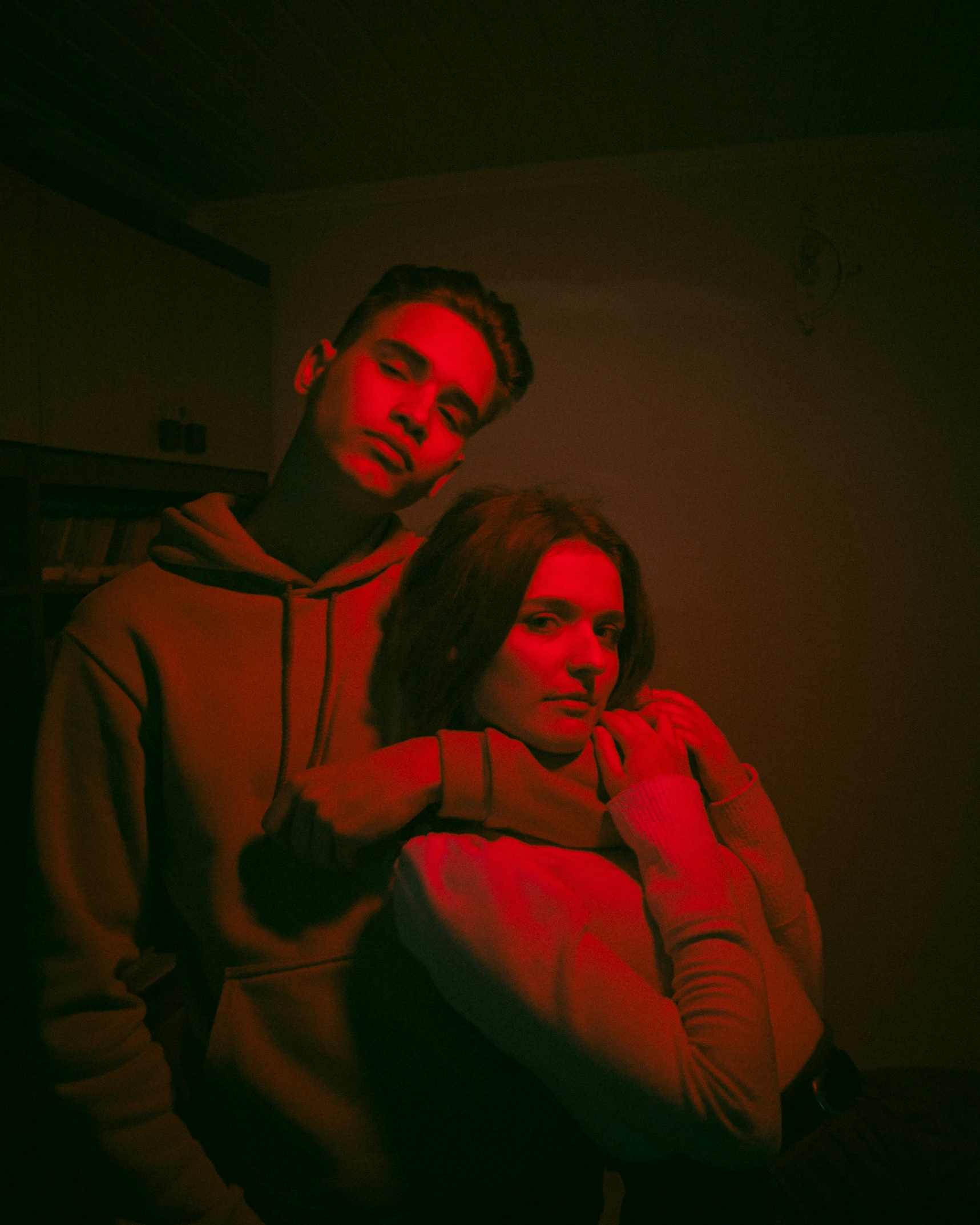 two people in dark room with red lighting