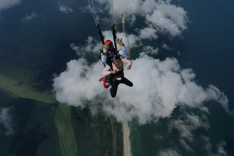 a pair of people are parasailing high above the clouds