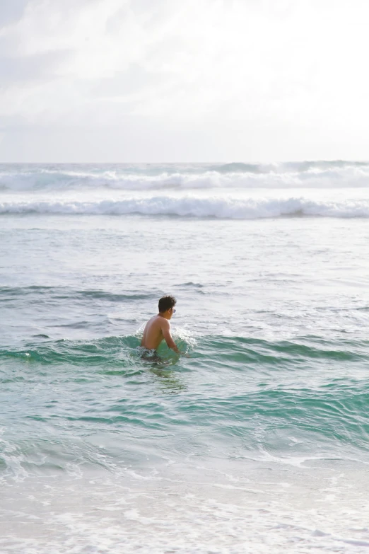 a man in the ocean wading out into water