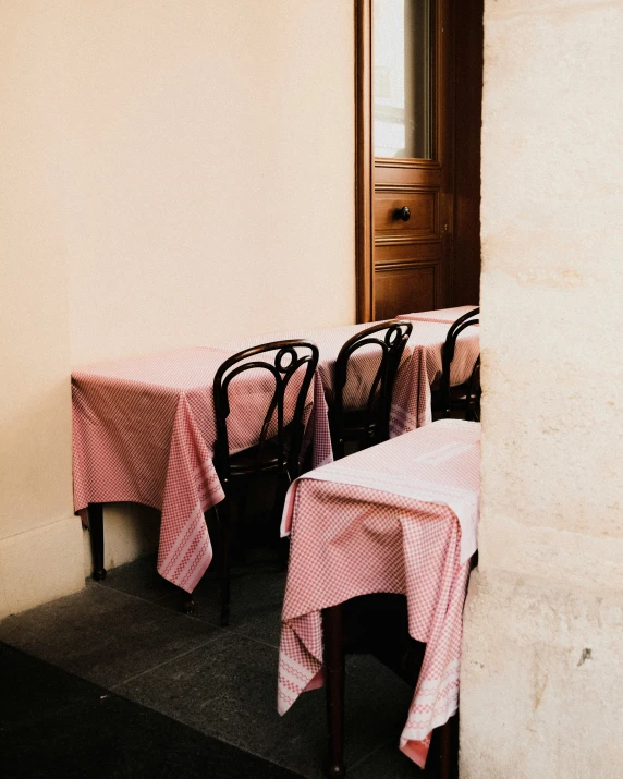 three tables covered with pink and white checkered tablecloths