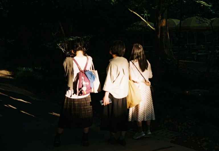 two ladies are carrying bags as they walk down the street