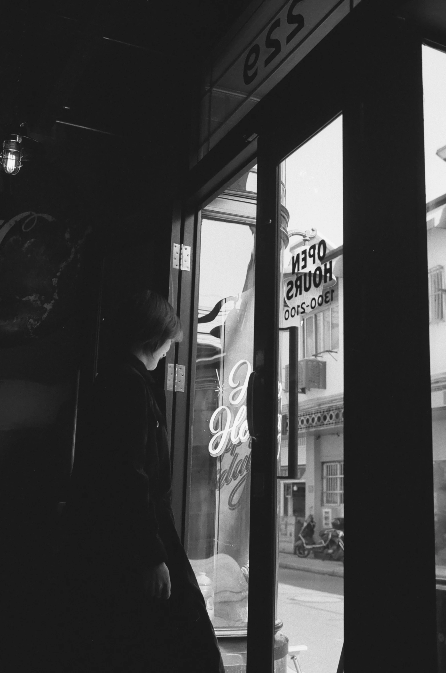 a woman looks through the window at a shop