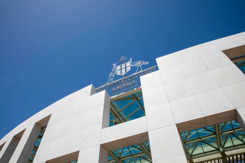 the large white building has three windows and a sign on top