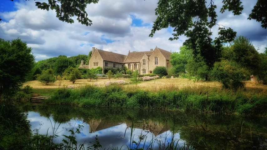 an old house sitting in the middle of a rural area with trees and grass