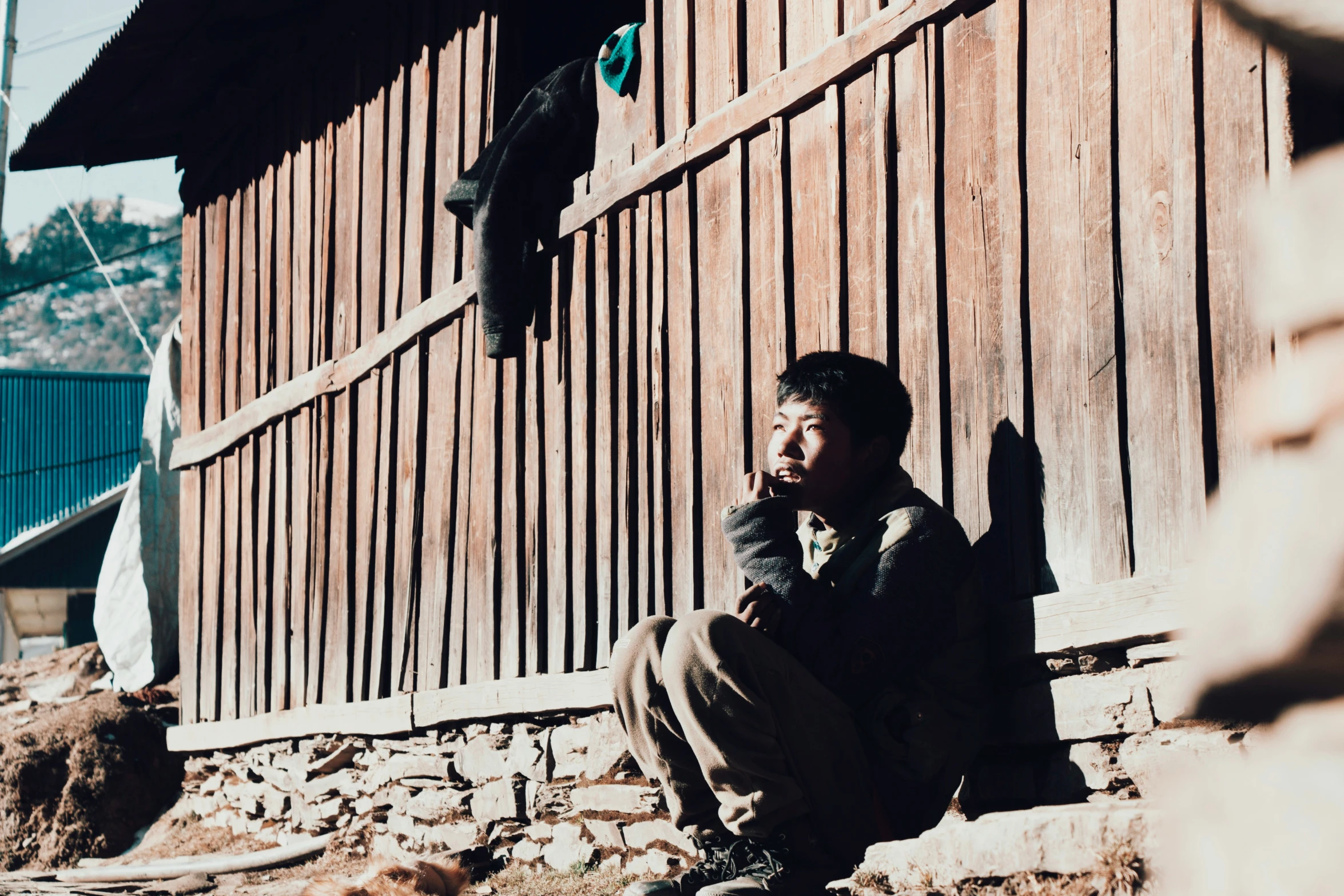 a man in a straw hat sits next to a building