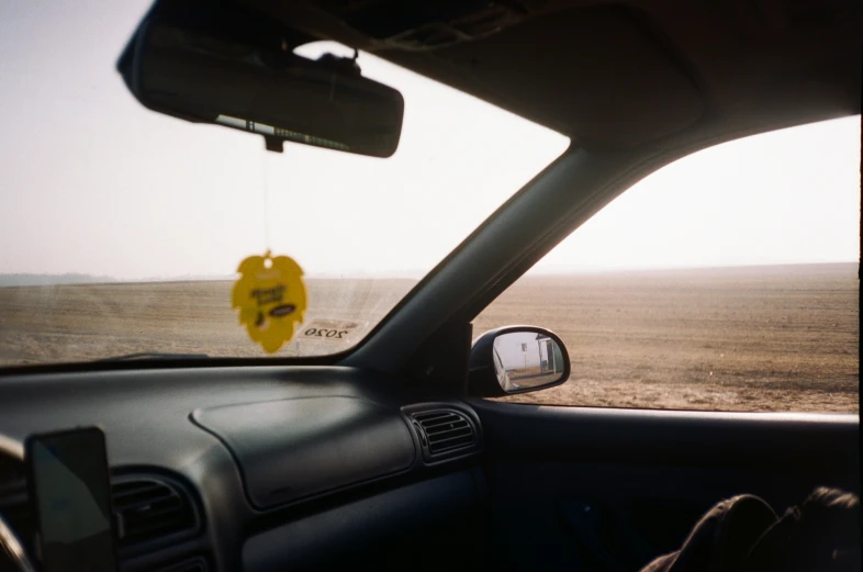 the dashboard of a car near a yellow sign