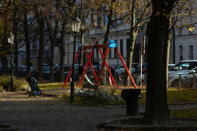 a red slide in a tree filled park