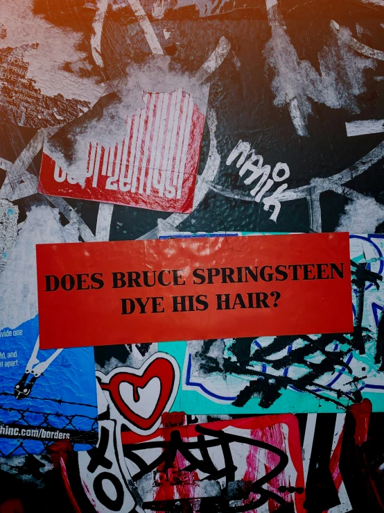 graffiti on the side of a wall, says does bruce springtean dye his hair?