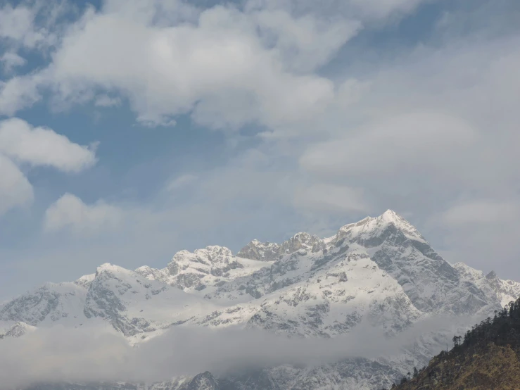 a group of snow covered mountains with very few clouds