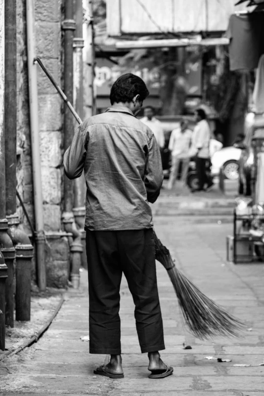 a man with an object sweeping the pavement